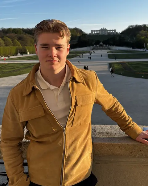 Otto Solala seisoo Schönbrunnin puiston terassilla Wienissä, taustalla puutarha ja Gloriette.